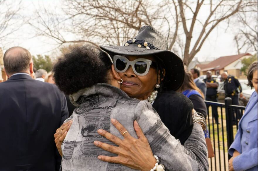 Sandy Joyce embracing a friend at the opening of Renaissance House